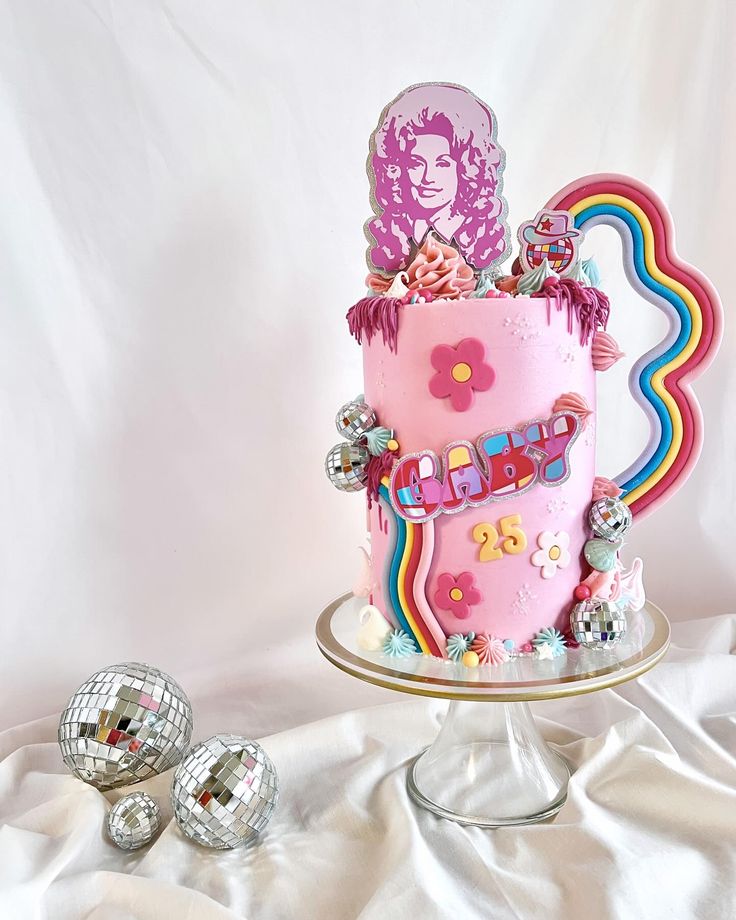 a pink birthday cake with decorations on it