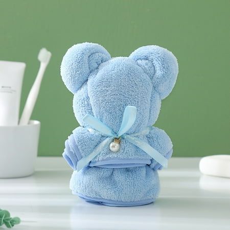 a blue teddy bear is wrapped in a towel