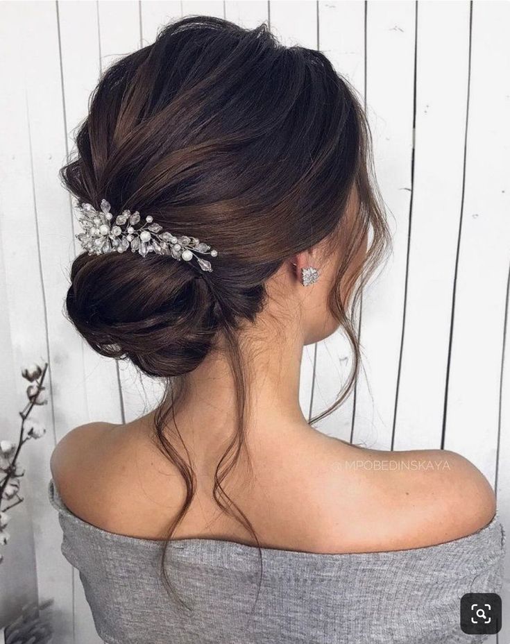 a woman wearing a hair comb with flowers in it's back and her hair pulled up into a low bun