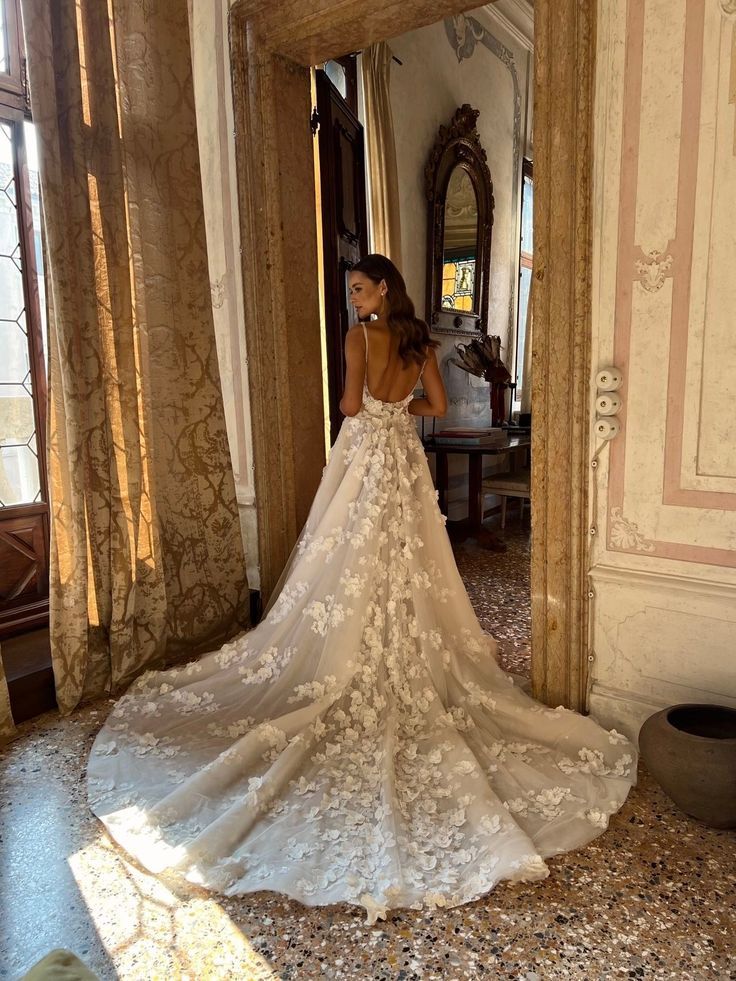 a woman in a wedding dress is looking at herself in the mirror