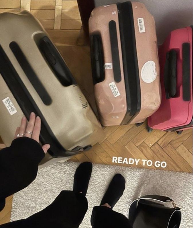 several suitcases are lined up on the floor and someone is holding their hand out