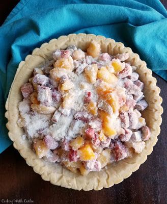 there is a pie with fruit in it on the table next to a blue napkin