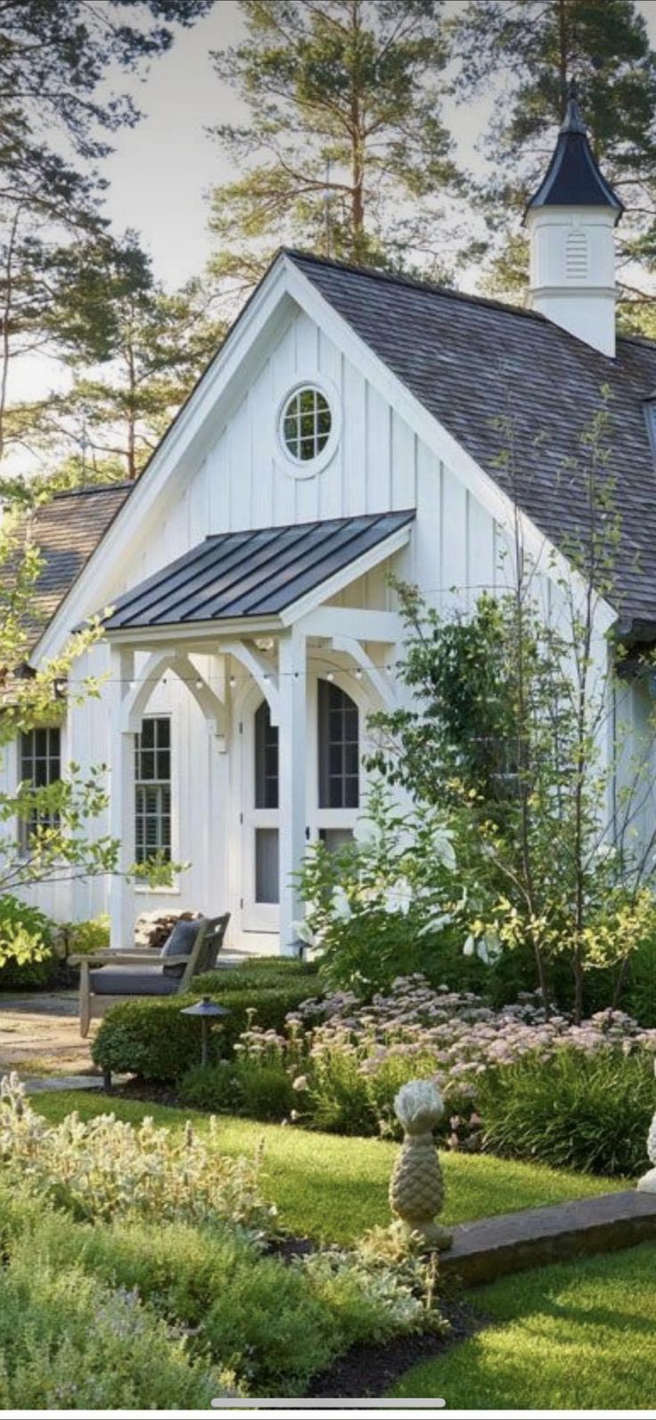 a white house surrounded by greenery and flowers