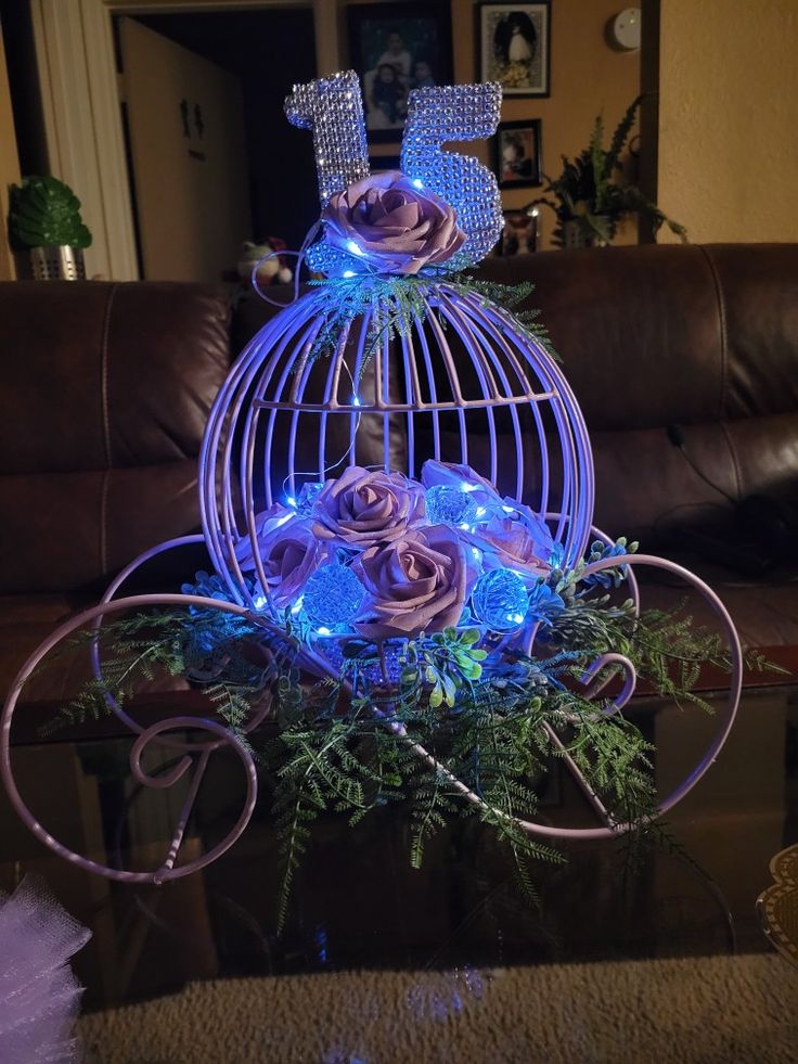 a decorative birdcage with roses and blue lights