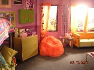 a bedroom with pink walls and furniture in the room is furnished with bright colored accessories