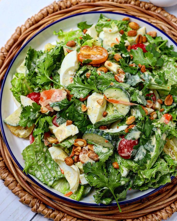 a salad with lettuce, cucumber, tomatoes and nuts on a plate