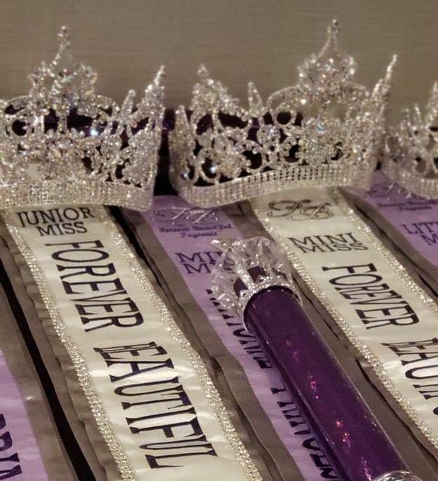 three purple toothbrushes are lined up next to each other with crowns on them