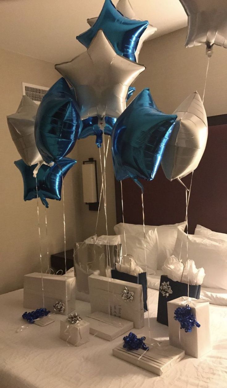 some blue and white balloons are on a bed