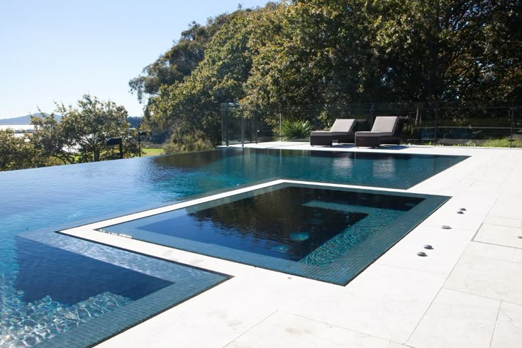 an empty swimming pool surrounded by trees and water