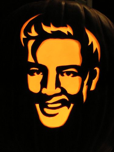 a carved pumpkin with the likeness of abraham lincoln on it's face, in front of a black background