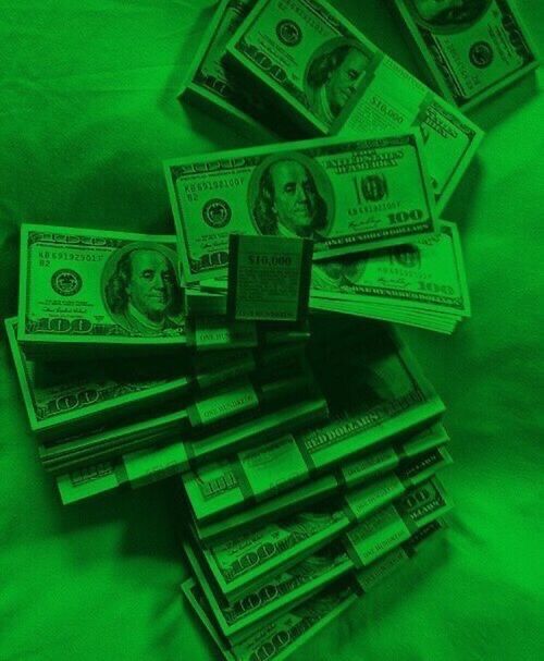 a pile of money sitting on top of a green sheeted bed covered in sheets