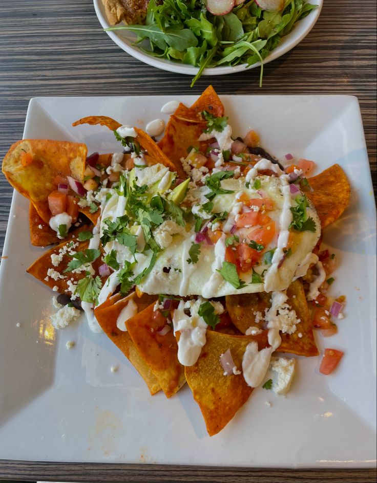 nachos and salad are served on a plate