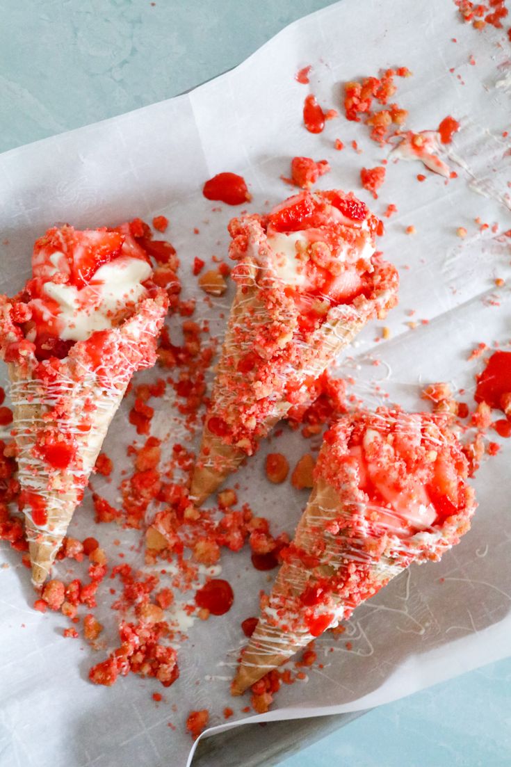 three pieces of pizza sitting on top of a piece of parchment paper covered in red pepper sprinkles