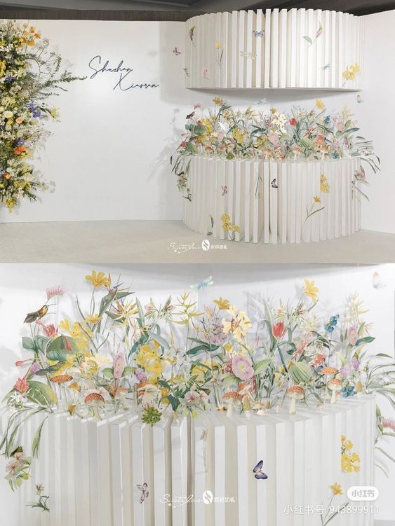 three tiered cake decorated with flowers and butterflies on the top, in front of a white wall