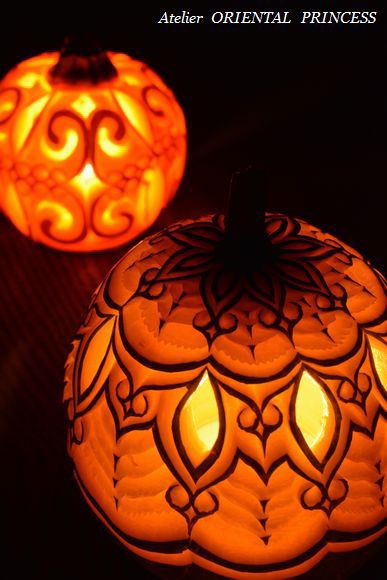 two carved pumpkins sitting on top of a table