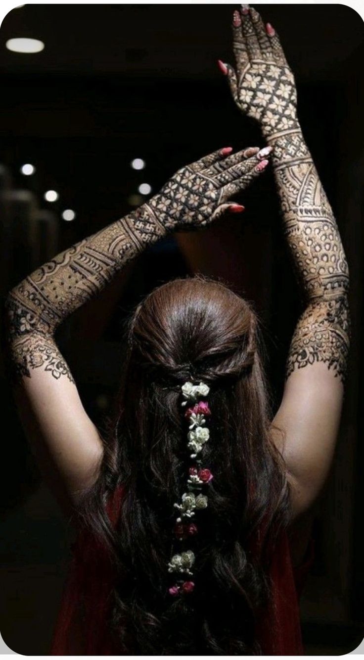 a woman with henna tattoos on her arms and hands