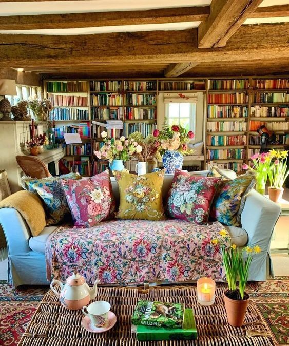 a living room filled with lots of furniture and bookshelves full of books on top of them