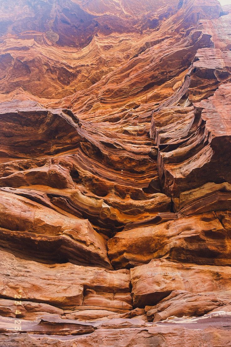 some very large rocks that are in the dirt and brown rock face with no leaves on them