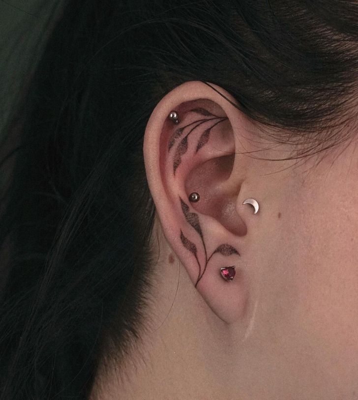 a woman's ear with two piercings on it