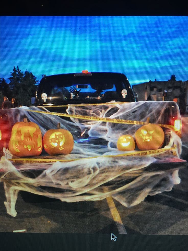 a truck decorated with pumpkins and ghost tape