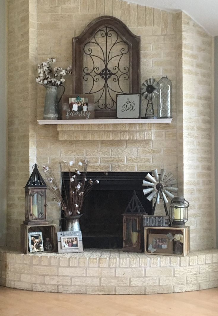 a living room filled with furniture and a fire place in front of a brick wall