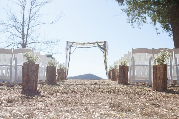 an outdoor ceremony set up with white chairs