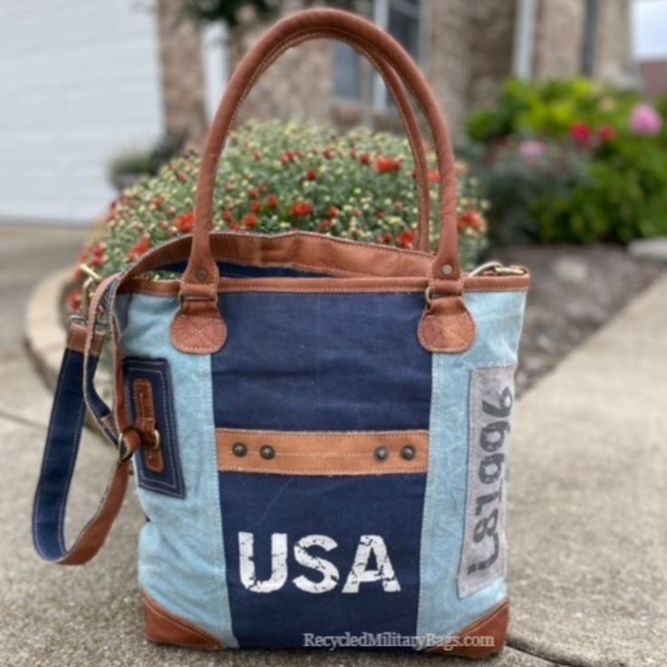 Blue two tone tote canvas and leather bag crafted of repurposed and upcycled sustainable Military Canvas into this great purse or tote bag. Plenty of room for everything you need. Convenient front pocket and adjustable crossbody strap make it the perfect bag to show your pride with ease, d comfort and style! A perfect gift for all those patriotic peeps, military moms, wives and all that just love a quality bag. 17" x 14.5" x 4" <<-- Please Check the DIMs! Fully Lined Inside Zip top Closure Leath Vintage Blue Shoulder Bag With Leather Handles, Upcycled Hobo Shoulder Bag, Everyday Upcycled Hobo Shoulder Bag, Casual Canvas Bags With Upcycled Details, Casual Upcycled Canvas Shoulder Bag, Vintage Reversible Bags For Everyday Use, Upcycled Canvas Shoulder Bag For Daily Use, Upcycled Tote Shoulder Bag For Everyday, Vintage Upcycled Shoulder Bag For Everyday Use