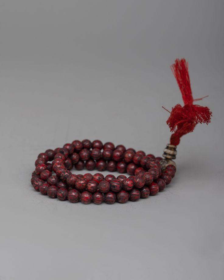 a red beaded bracelet with a tassel