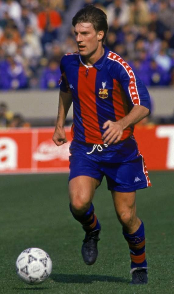 a soccer player is running with the ball in his hand and people are watching from the stands