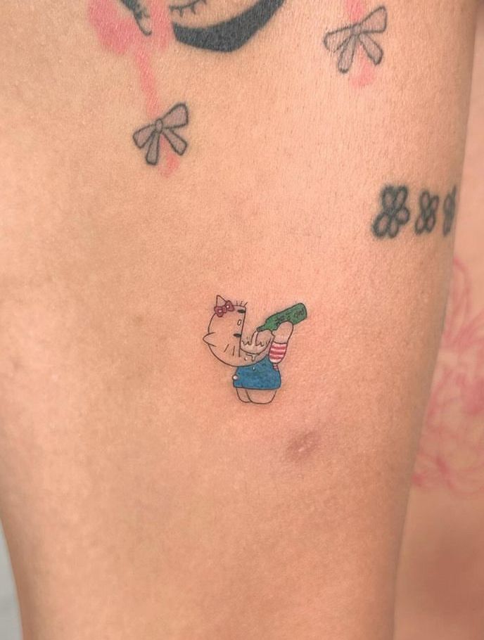 a woman's thigh with tattoos on it and an image of a pig holding a baseball bat