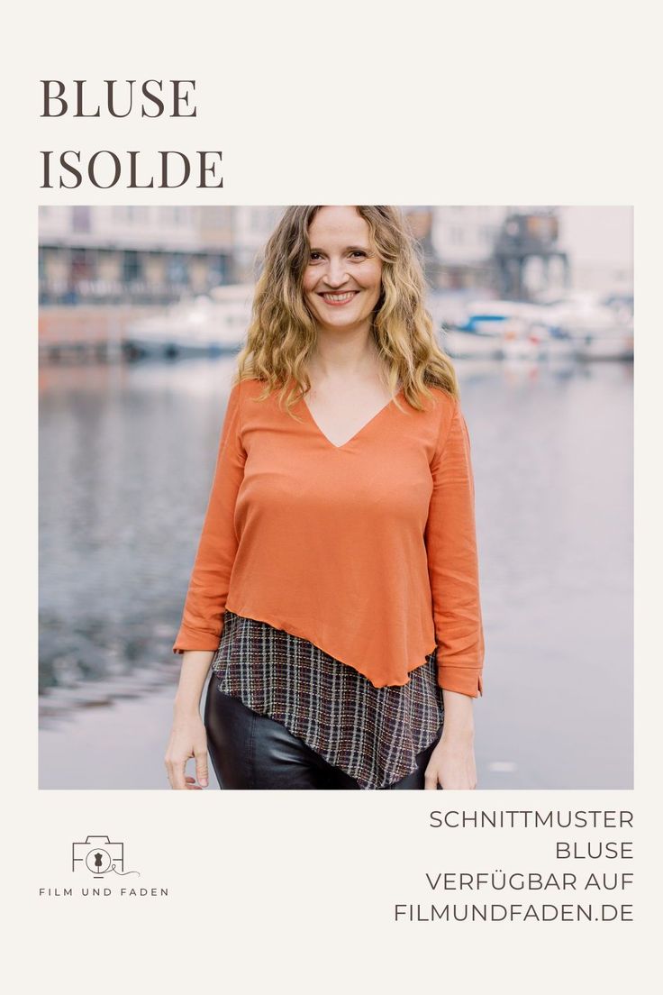 a woman standing in front of a body of water wearing an orange top and black leather pants