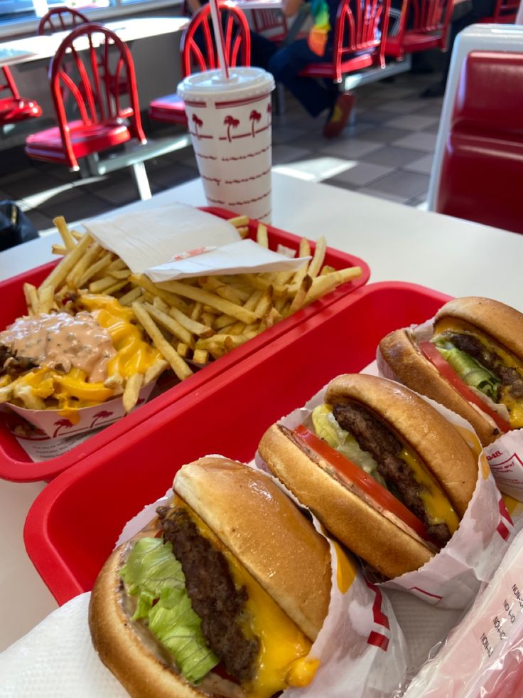 two trays filled with sandwiches and fries on top of a table