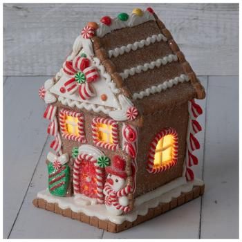 a lit up gingerbread house with candy canes