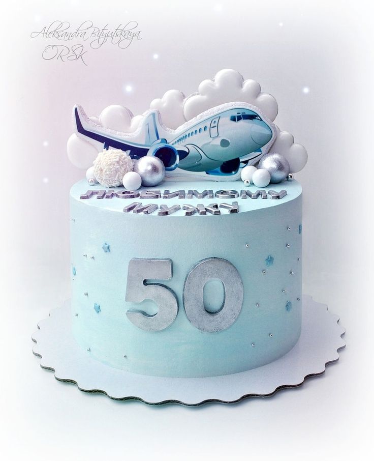 a birthday cake for someone's 50th with an airplane on top and the number 50