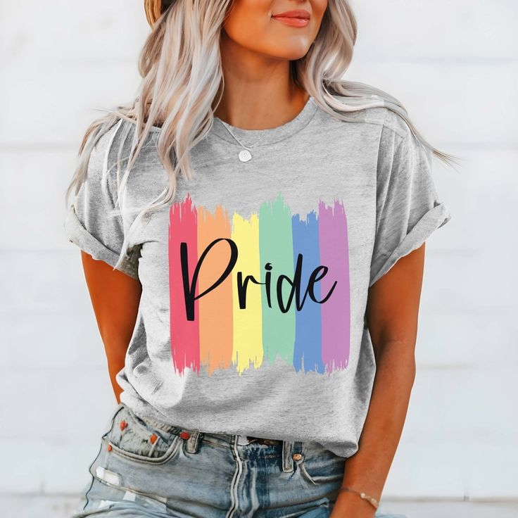 The "Pride Paint Strokes" Graphic Tee is more than just a garment; it's a vibrant celebration of diversity, love, and unity within the LGBTQ+ community. Crafted with meticulous attention to detail, this tee combines comfort with style, making it the perfect choice for expressing your pride and solidarity. The colorful rainbow paint strokes create a bold and eye-catching design, symbolizing the spectrum of identities and experiences within the LGBTQ+ community. Whether you're marching in a pride Cotton T-shirt With Rainbow Print For Pride, Relaxed Fit Crew Neck T-shirt For Pride, Spring Multicolor T-shirt With Text Print, Trendy Multicolor Pride T-shirt, Pride Slogan T-shirt With Short Sleeves, Pride Slogan T-shirt Short Sleeve, Spring Multicolor Slogan T-shirt, Trendy Rainbow Top For Pride, Trendy Crew Neck T-shirt For Pride