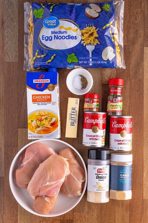 ingredients for chicken soup laid out on a wooden table