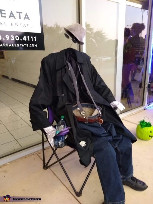 a man sitting in a chair with a hat on his head