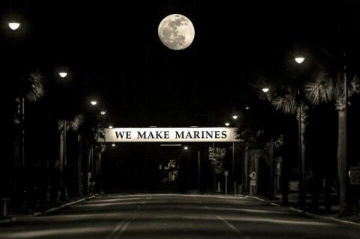 an empty street at night with the moon in the sky and we make marines sign above it