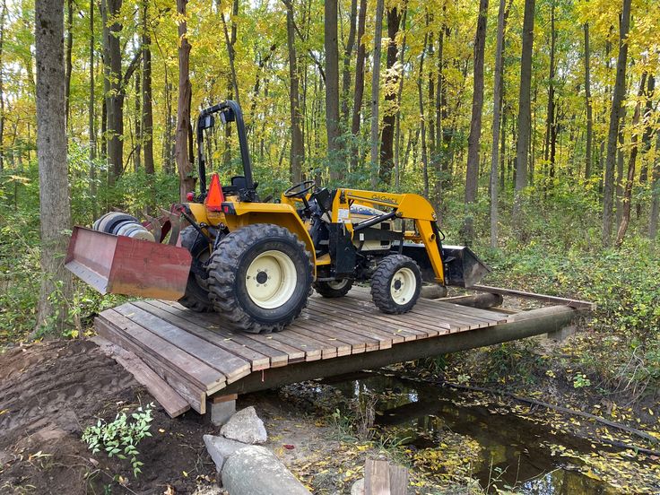 a tractor that is sitting on a wooden bridge