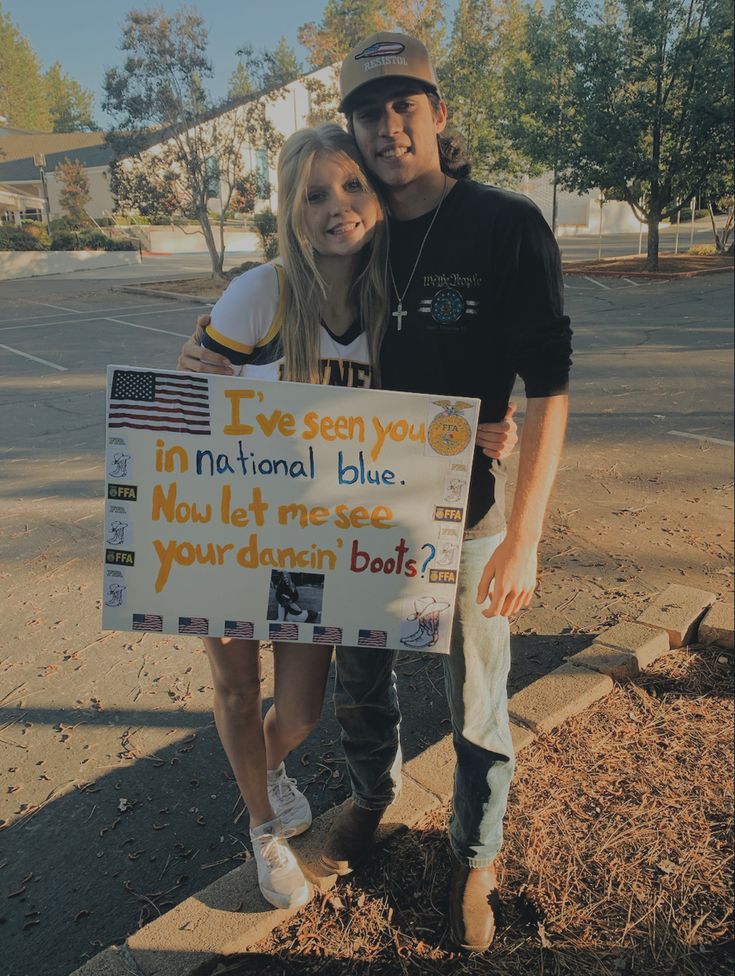 a man and woman standing next to each other holding a sign that says, i've been you in national blue now let me see your damn boat?