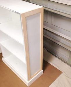 a white book shelf sitting on top of a hard wood floor