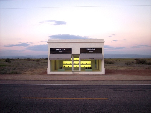 an empty building sitting on the side of a road at dusk with no people around it