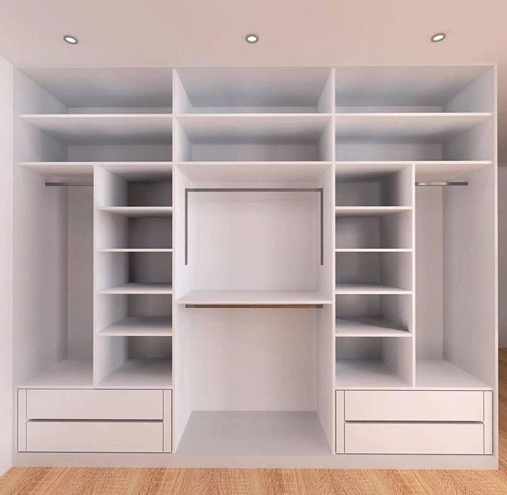 an empty white closet with shelves and drawers on the wall, in front of a wooden floor