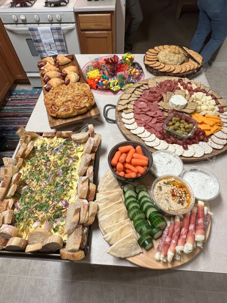 a table filled with different types of food on top of a kitchen counter next to an oven