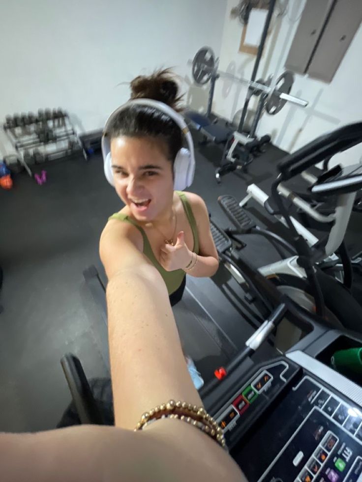 a woman is running on a treadmill and listening to music with headphones in her ears