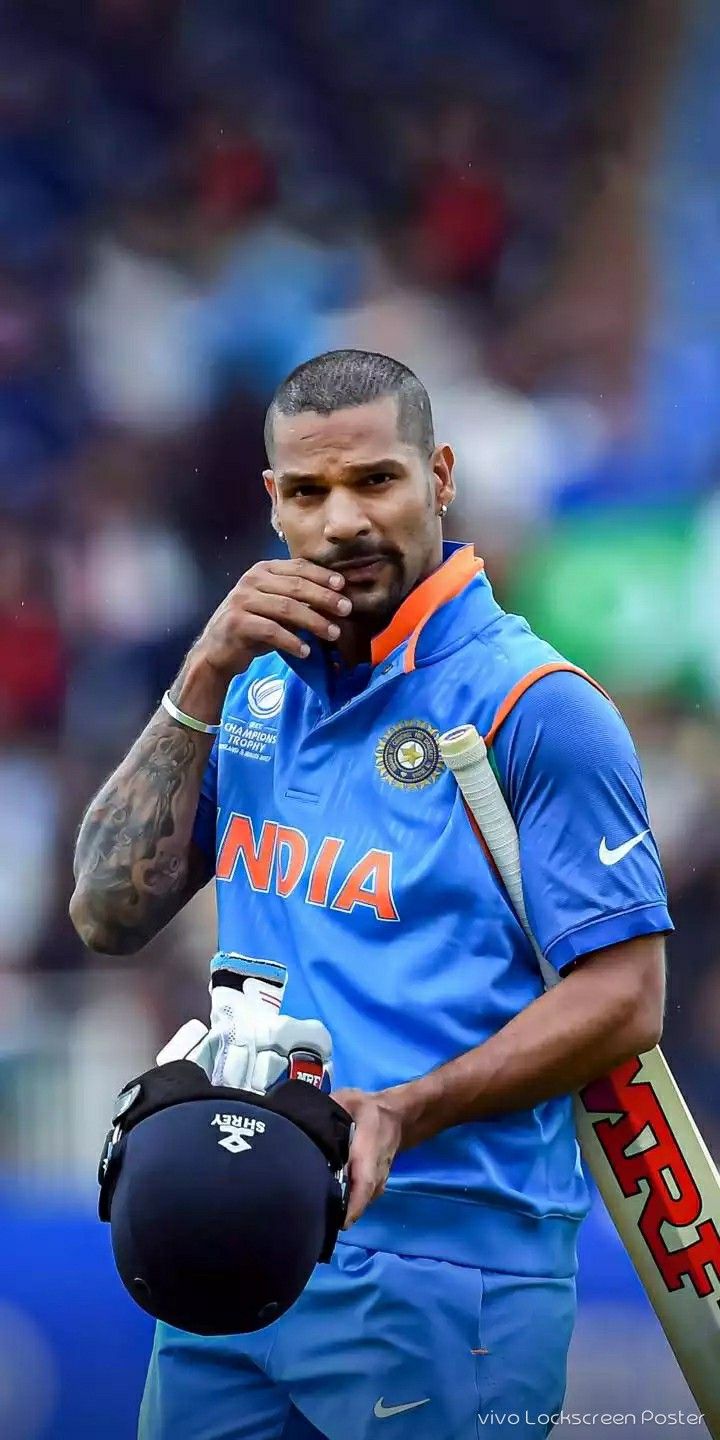 a man holding a baseball bat and wearing a blue uniform with an orange stripe on it