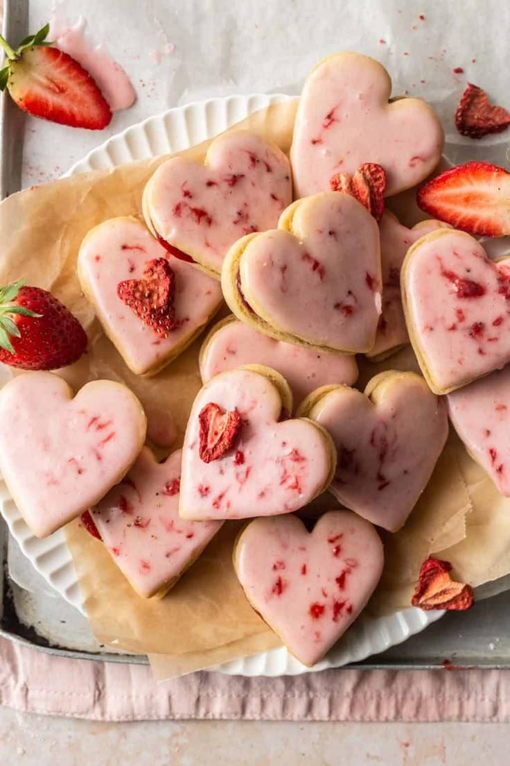 strawberry shortbread cookies on a white plate with strawberries in the shape of hearts