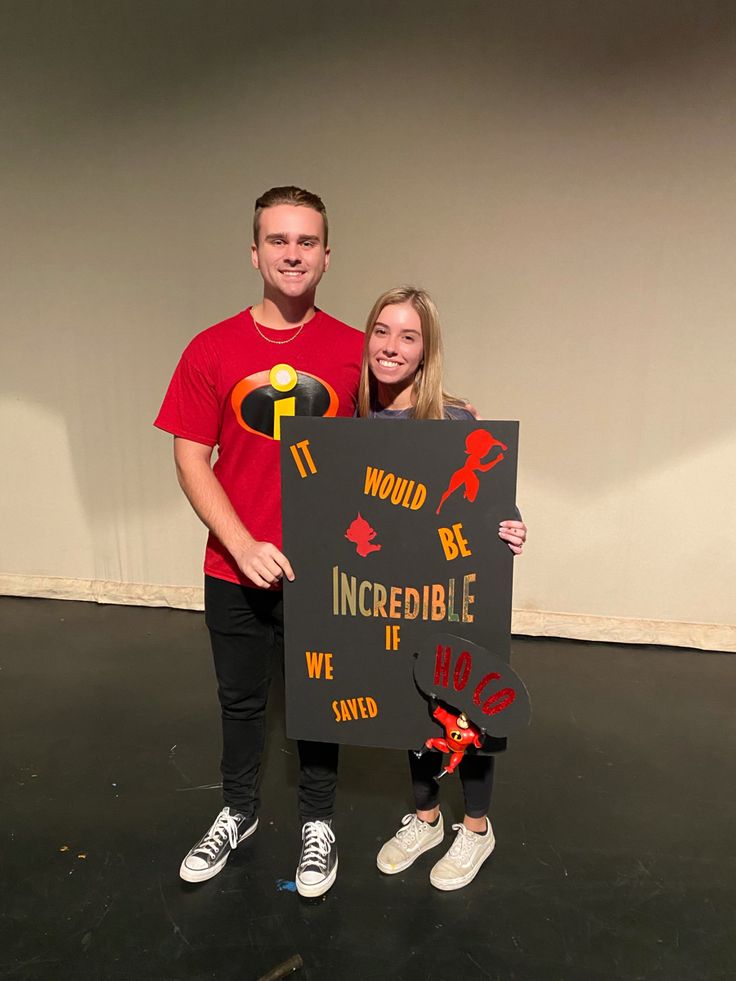 a man and woman standing next to each other holding a sign that says incredible in front of them