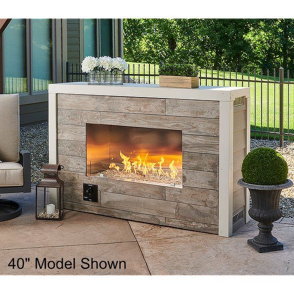 an outdoor fireplace in the middle of a patio