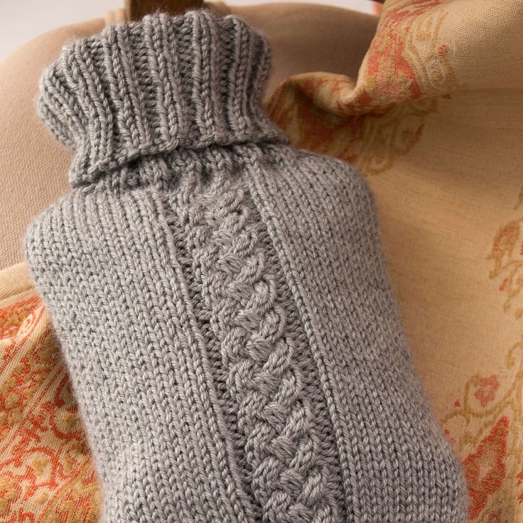 a gray knitted bottle cover sitting on top of a couch